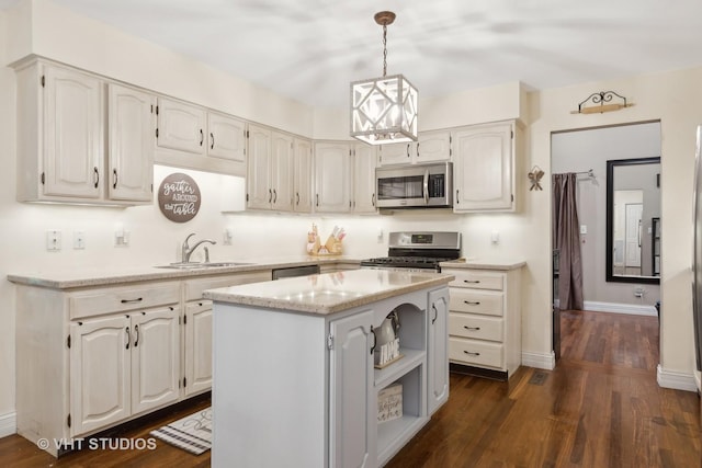 kitchen with sink, dark wood-type flooring, hanging light fixtures, stainless steel appliances, and a kitchen island