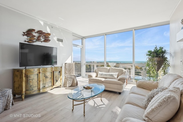 living room with a wall of windows, visible vents, and wood finished floors