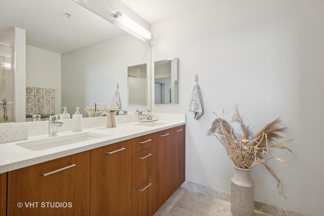 full bathroom featuring double vanity, a shower with door, and a sink