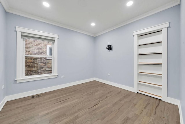 empty room featuring ornamental molding and light hardwood / wood-style flooring