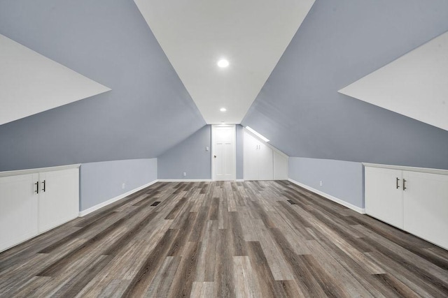 additional living space with vaulted ceiling and dark wood-type flooring