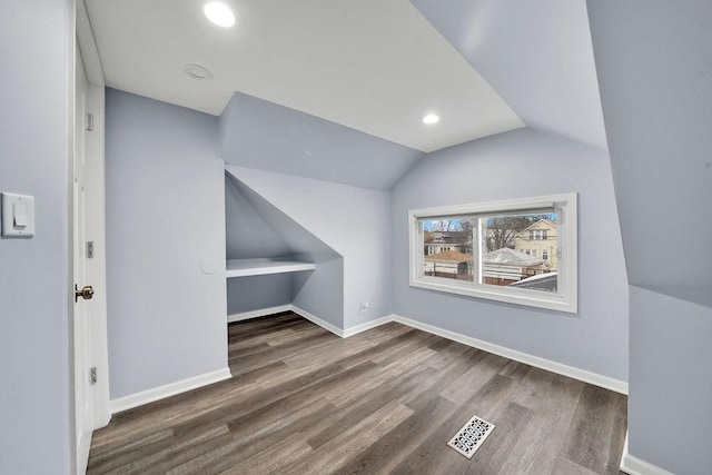 bonus room featuring dark hardwood / wood-style floors and vaulted ceiling