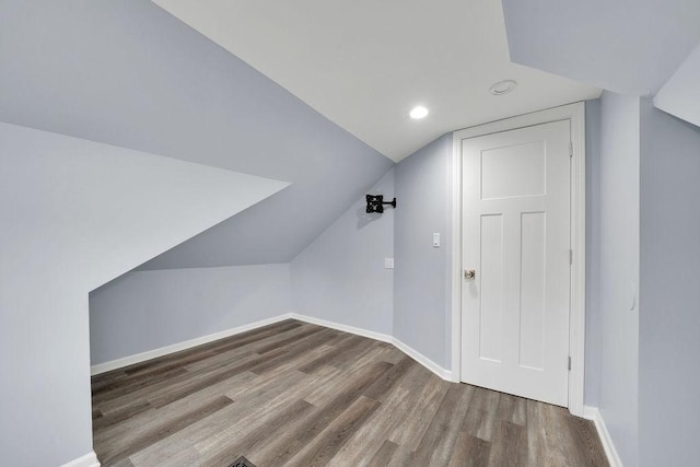 additional living space featuring hardwood / wood-style floors and lofted ceiling