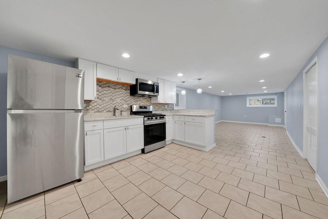 kitchen featuring white cabinetry, sink, stainless steel appliances, tasteful backsplash, and kitchen peninsula