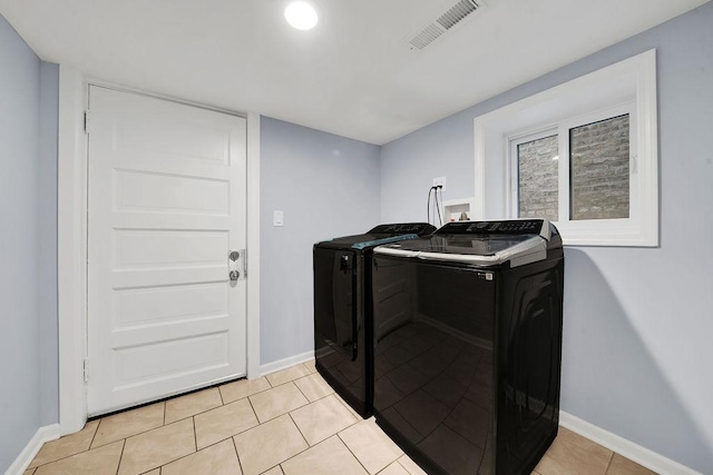 laundry room with washer and dryer and light tile patterned flooring