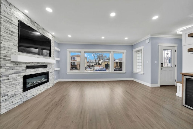 unfurnished living room featuring crown molding, a fireplace, and hardwood / wood-style flooring