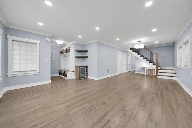 unfurnished living room featuring light hardwood / wood-style floors, ornamental molding, and radiator