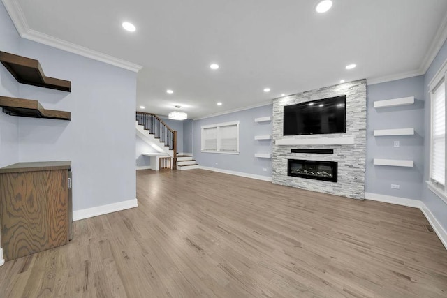 unfurnished living room with a fireplace, light wood-type flooring, plenty of natural light, and ornamental molding