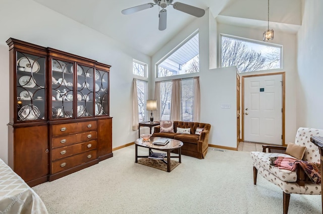 living room featuring ceiling fan with notable chandelier, light colored carpet, and high vaulted ceiling