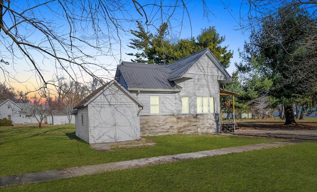 property exterior at dusk featuring a lawn