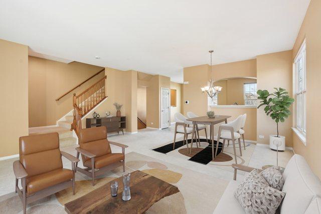 carpeted living room with a chandelier