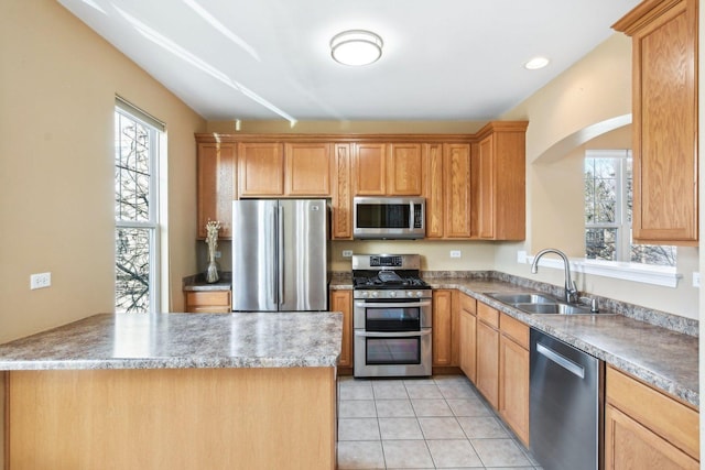 kitchen featuring stainless steel appliances, sink, and light tile patterned floors