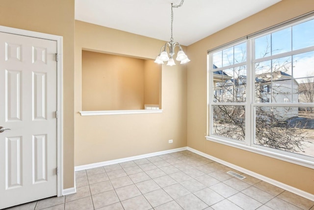 unfurnished dining area featuring an inviting chandelier and light tile patterned floors