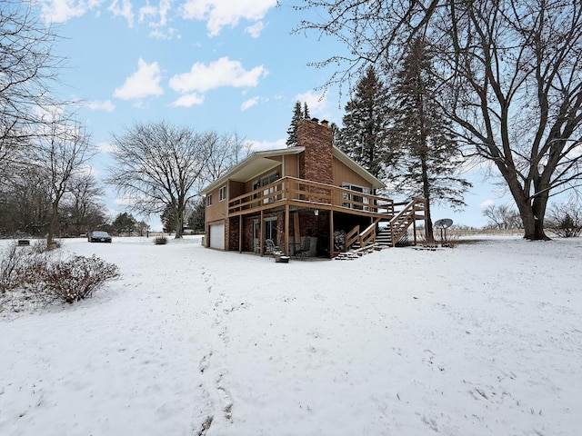 snow covered rear of property with a wooden deck