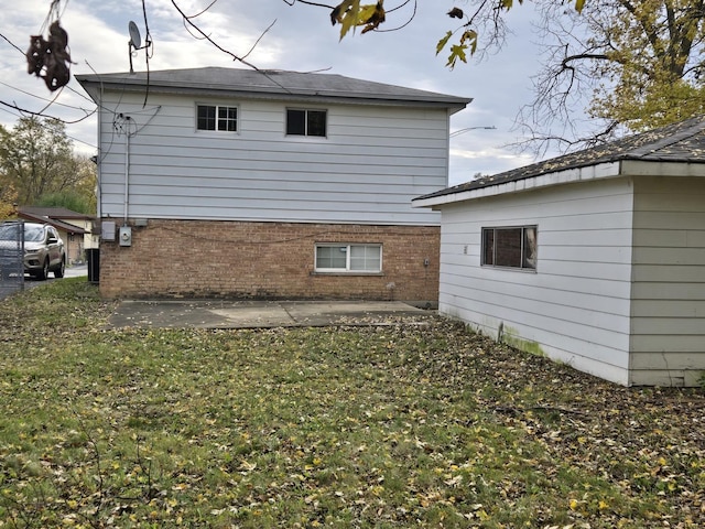 back of house featuring a lawn and a patio area