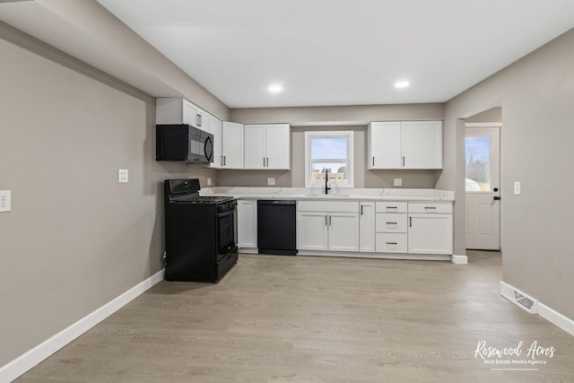 kitchen with white cabinets, sink, light hardwood / wood-style flooring, and black appliances