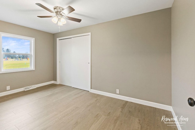 unfurnished bedroom with ceiling fan, light hardwood / wood-style flooring, and a closet