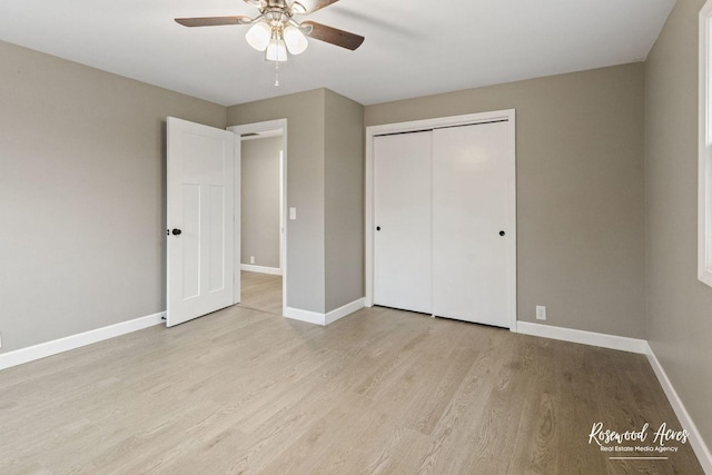 unfurnished bedroom with ceiling fan, light wood-type flooring, and a closet