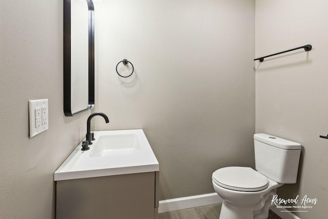 bathroom featuring hardwood / wood-style floors, vanity, and toilet