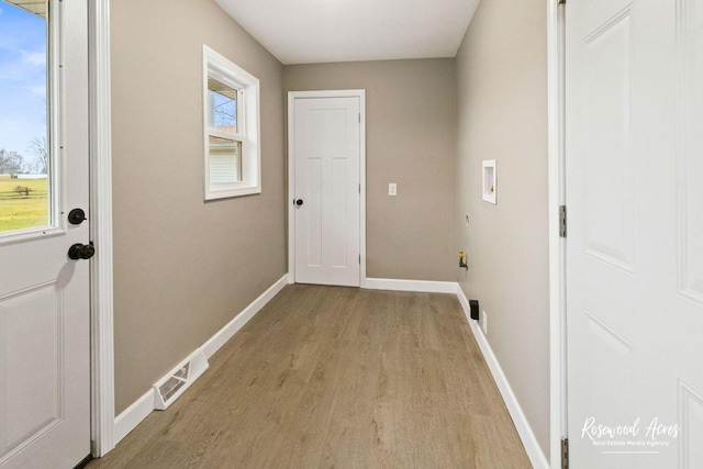 laundry room with hookup for a washing machine and light hardwood / wood-style flooring