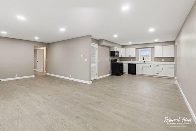 unfurnished living room with light hardwood / wood-style flooring and sink