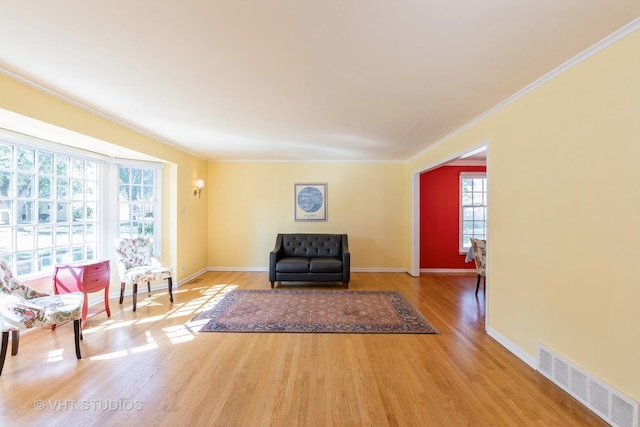 unfurnished room with crown molding, plenty of natural light, and hardwood / wood-style flooring