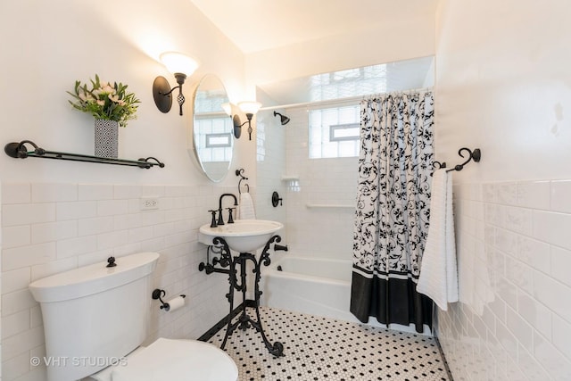 bathroom featuring tile patterned flooring, shower / bath combo, toilet, and tile walls