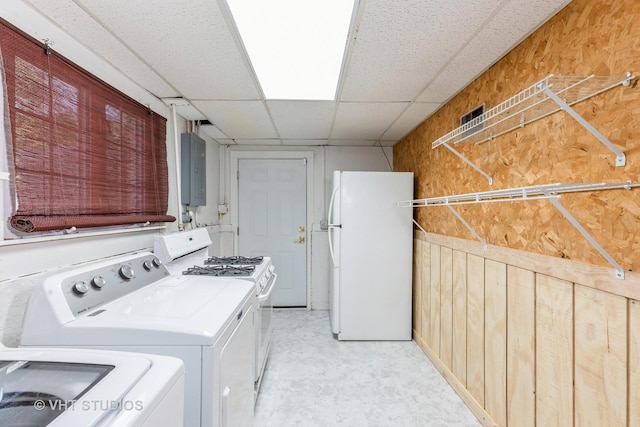 clothes washing area with electric panel and wooden walls