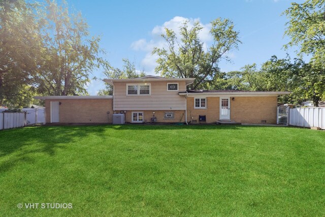 rear view of house with a lawn and central AC unit