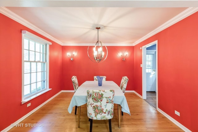 dining space with hardwood / wood-style floors, crown molding, and a notable chandelier