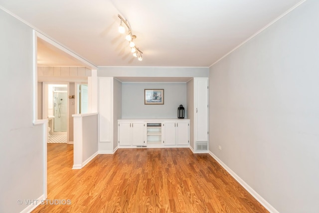 interior space featuring crown molding and light hardwood / wood-style flooring