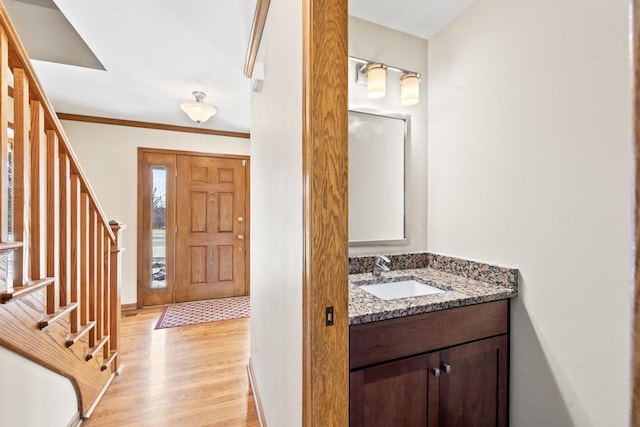 bathroom featuring wood-type flooring, vanity, and crown molding