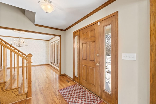 entrance foyer featuring crown molding, a chandelier, and light hardwood / wood-style flooring