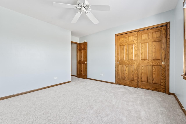 unfurnished bedroom with ceiling fan, a closet, and light carpet