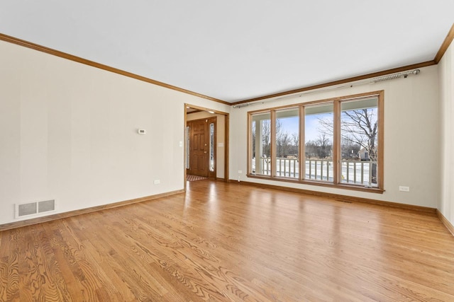 empty room with crown molding and light hardwood / wood-style flooring