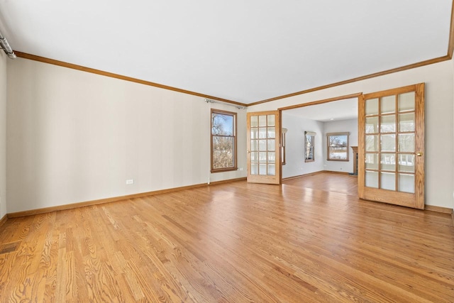 spare room with ornamental molding, french doors, and light wood-type flooring