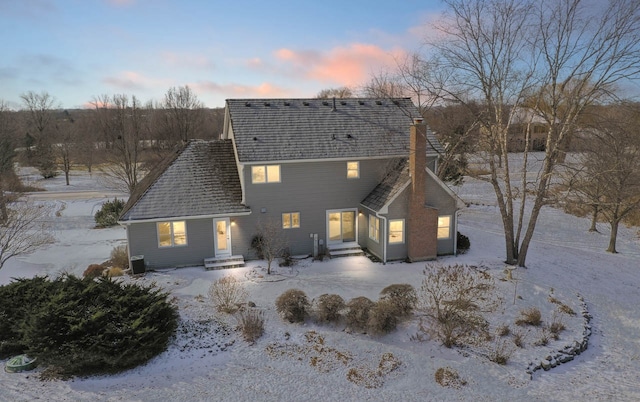 snow covered rear of property with cooling unit