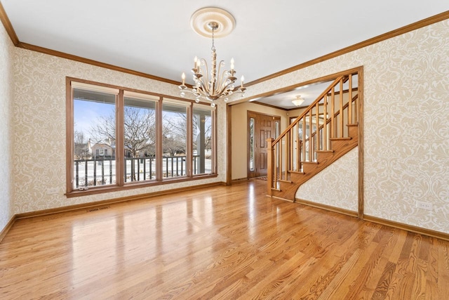 interior space with crown molding, hardwood / wood-style floors, and an inviting chandelier