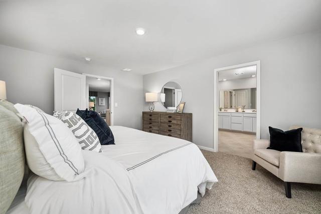 bedroom with ensuite bathroom and light carpet