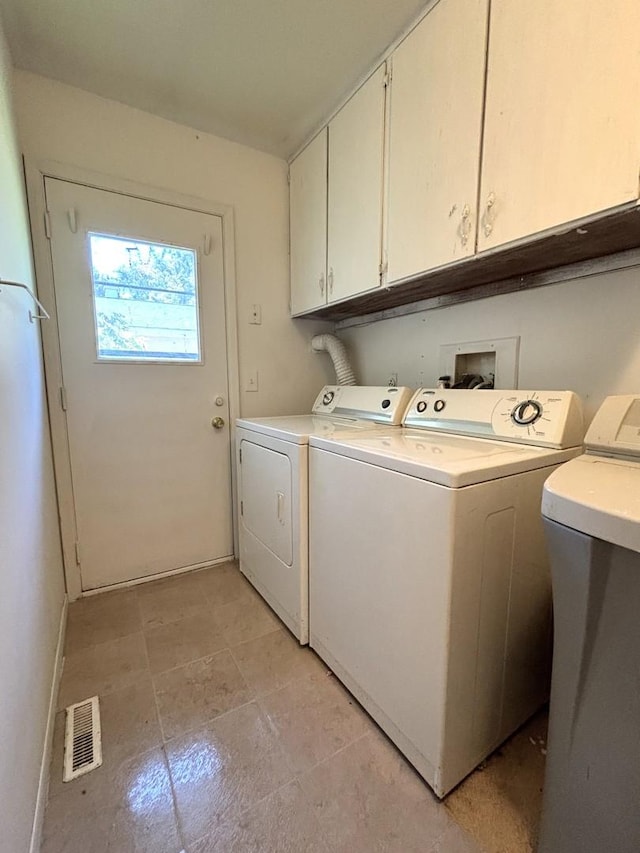 laundry area featuring washing machine and dryer and cabinets