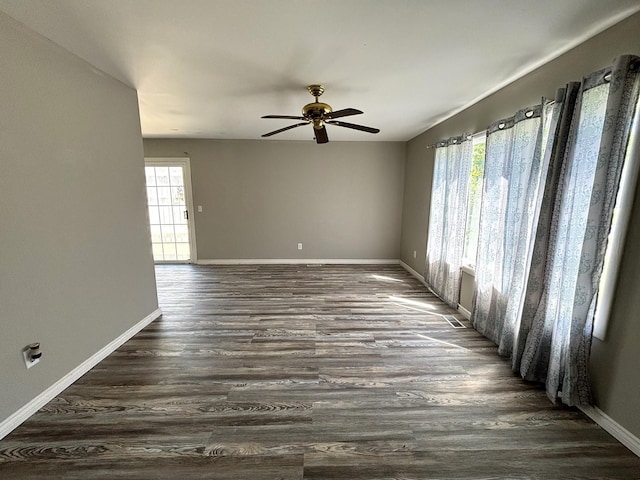 unfurnished room featuring a wealth of natural light, dark hardwood / wood-style flooring, and ceiling fan