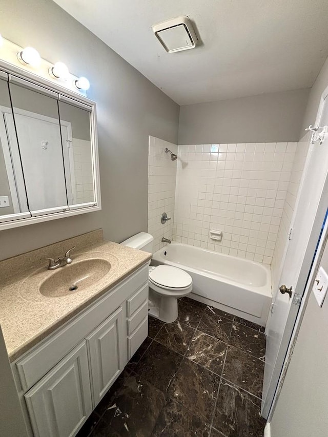 full bathroom with vanity, tiled shower / bath combo, and toilet