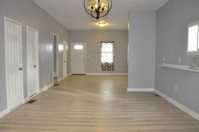 entrance foyer featuring light wood-type flooring and an inviting chandelier