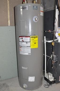 utility room featuring heating unit and water heater