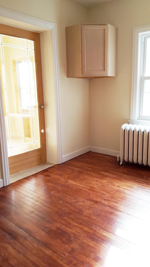 spare room featuring radiator heating unit and light hardwood / wood-style floors