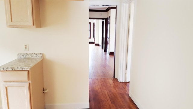 hallway with dark hardwood / wood-style floors and ornamental molding