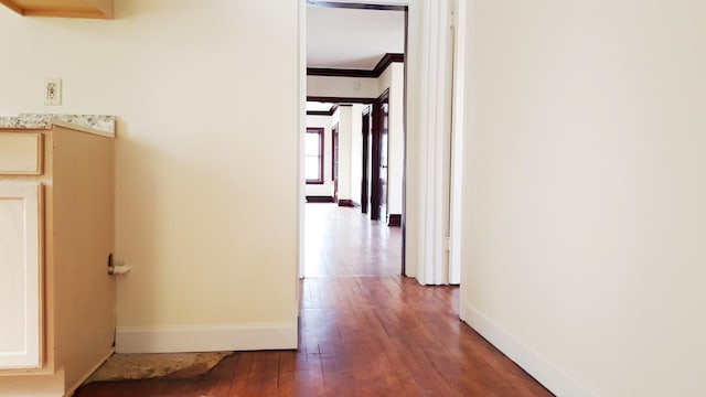 hall with dark hardwood / wood-style flooring and ornamental molding