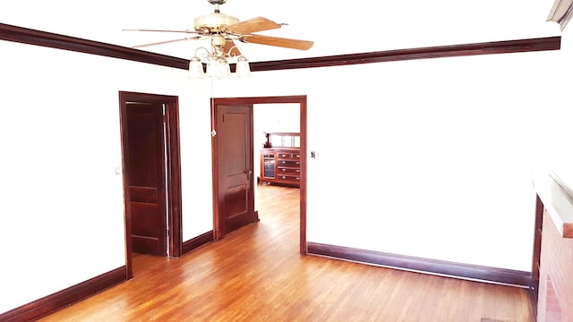 empty room featuring light hardwood / wood-style flooring, ceiling fan, and ornamental molding