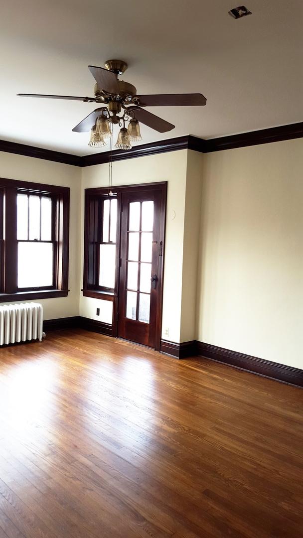 unfurnished room with hardwood / wood-style flooring, radiator, ornamental molding, and ceiling fan