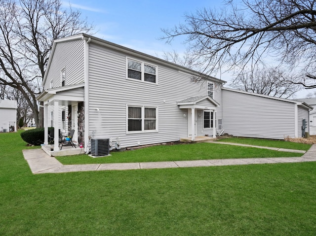 rear view of property with a lawn and cooling unit